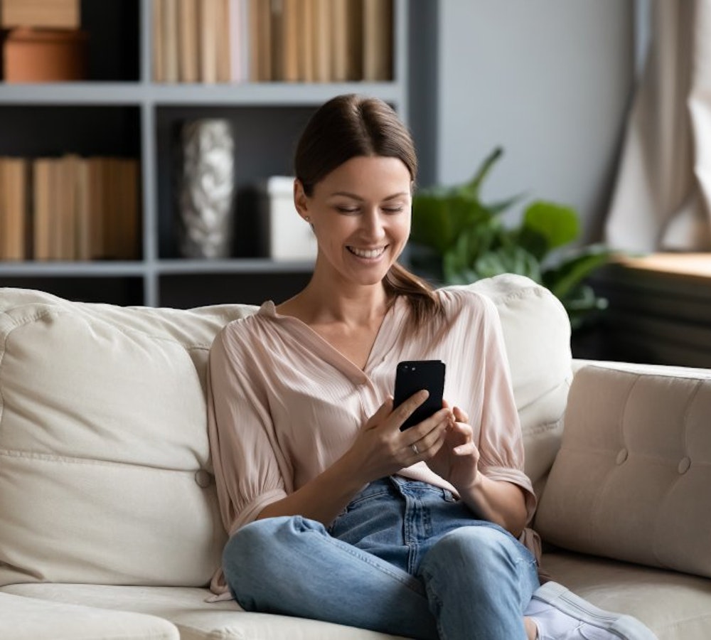 Woman relaxing at home on her phone